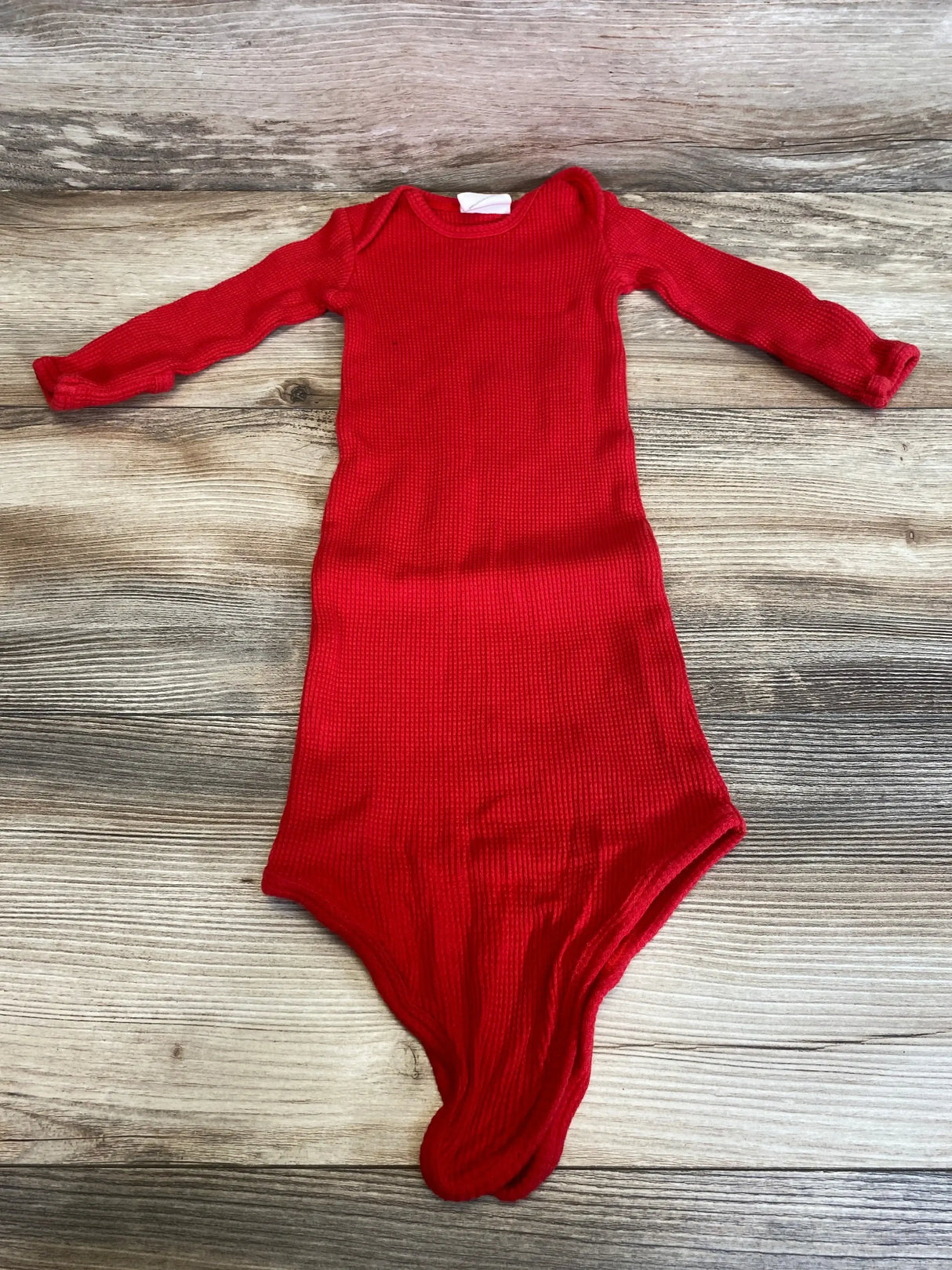 Flat lay front view of Spearmint Love waffle knotted baby gown size 0-3M showcasing knotted bottom and waffle texture on wood background