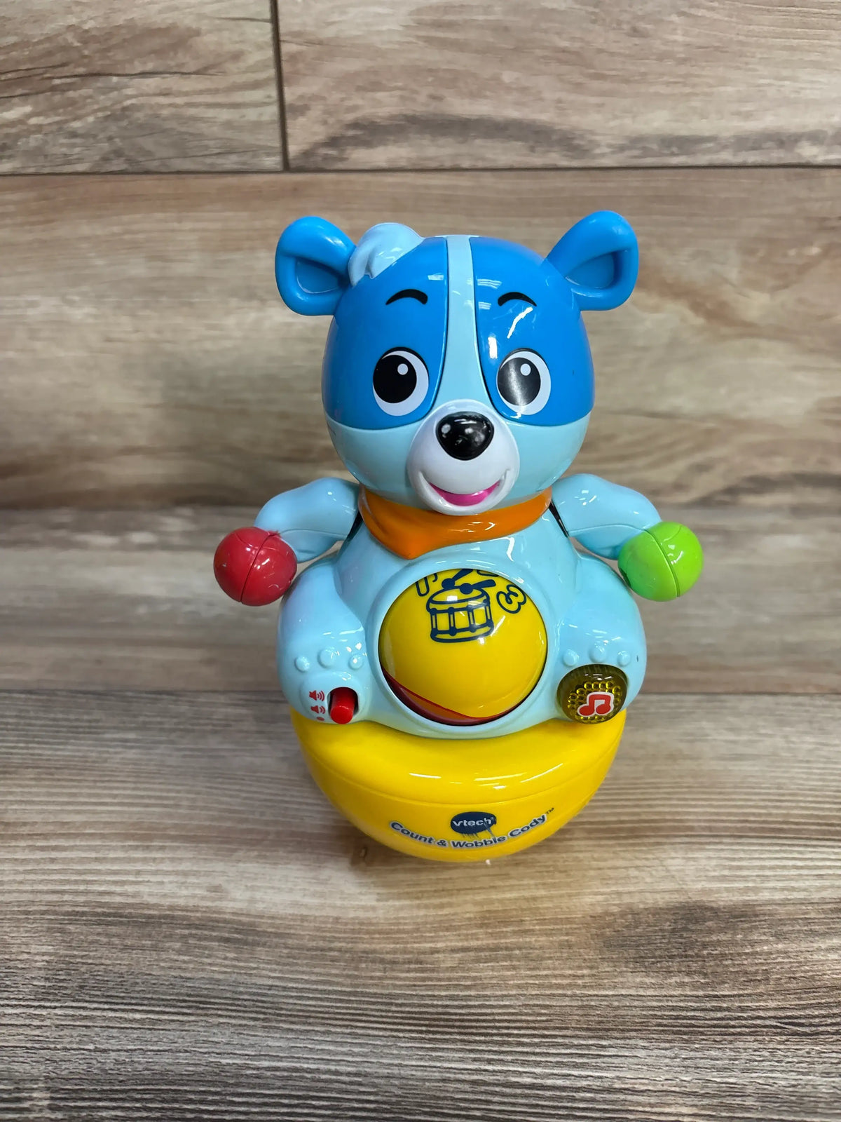 Front view of VTech Count and Cobble Cody toy showcasing rolling tummy ball and colorful buttons with a wood floor