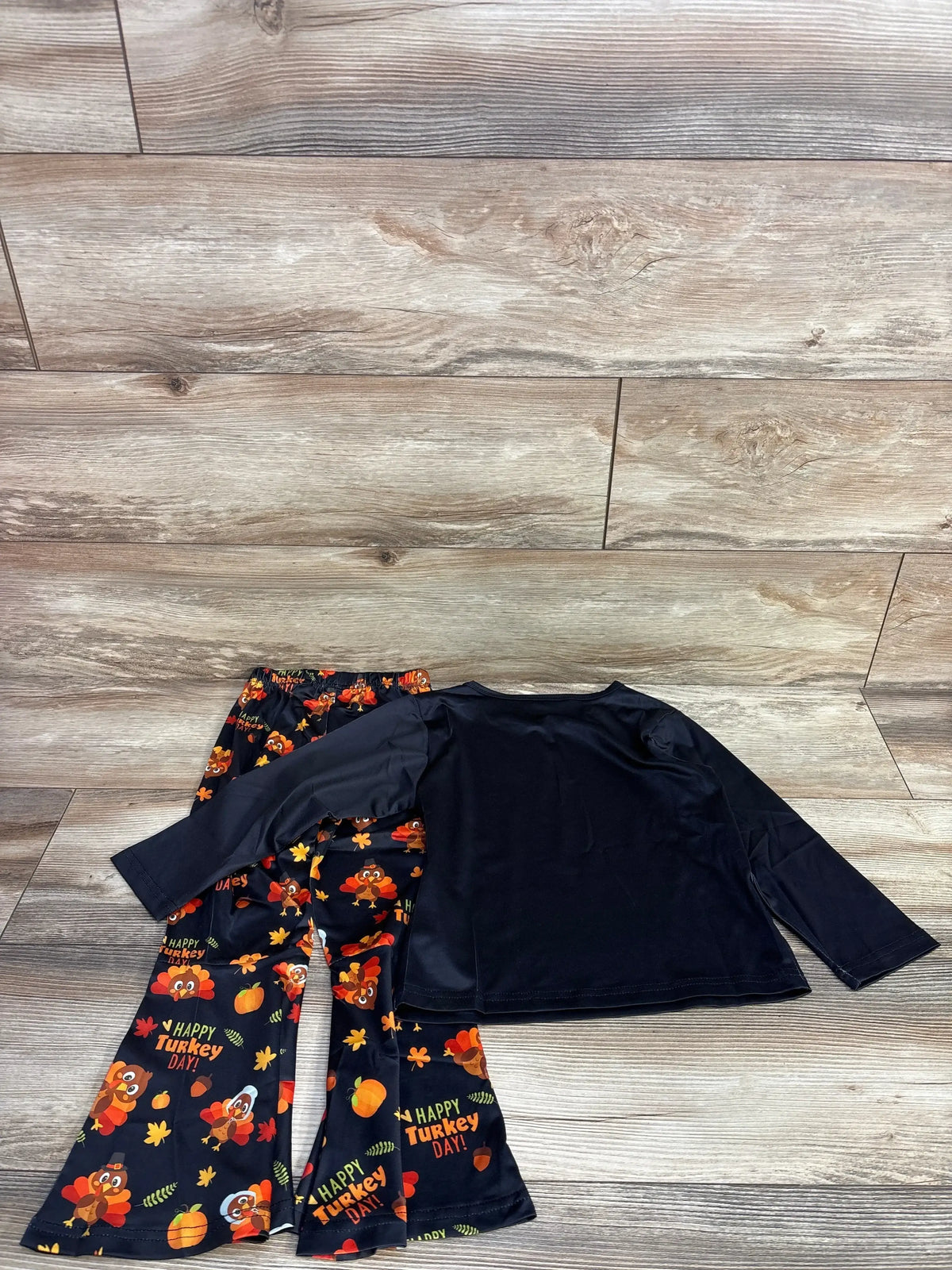 Kids' Happy Turkey Day outfit with black long sleeve shirt and festive turkey print pants
