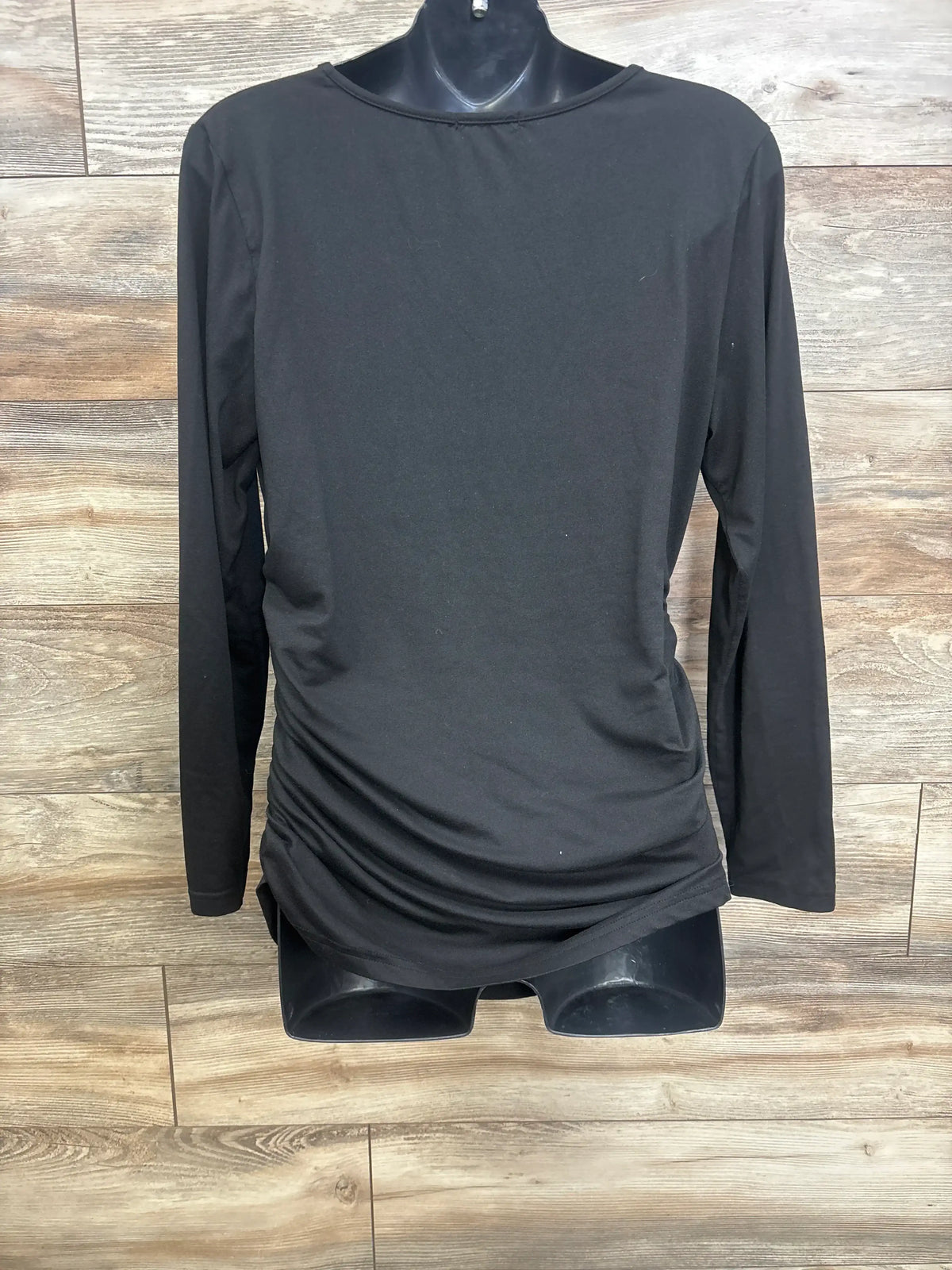 Front view of Ekouaer maternity black long-sleeve shirt showing side ruching and crew neck on mannequin against wood background