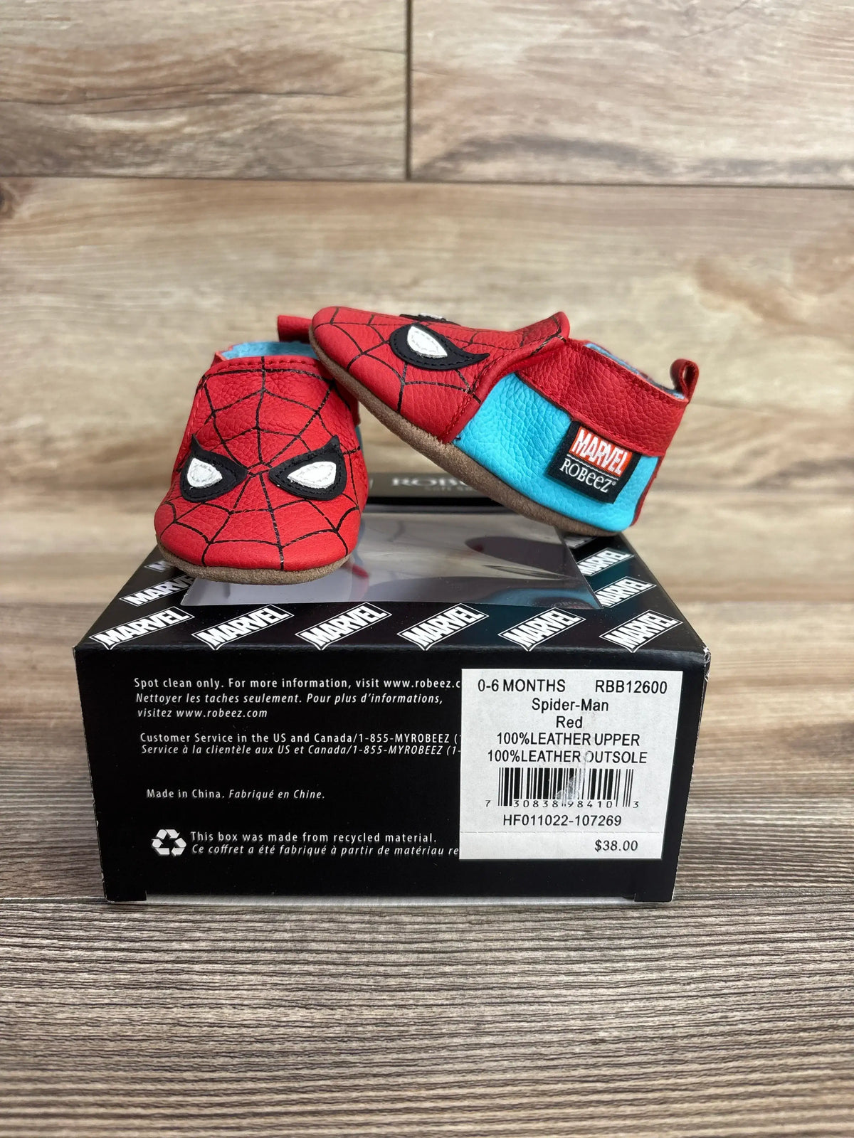 Red and blue Spider-Man themed baby shoes for 0-6 months with Marvel label, displayed on a branded box