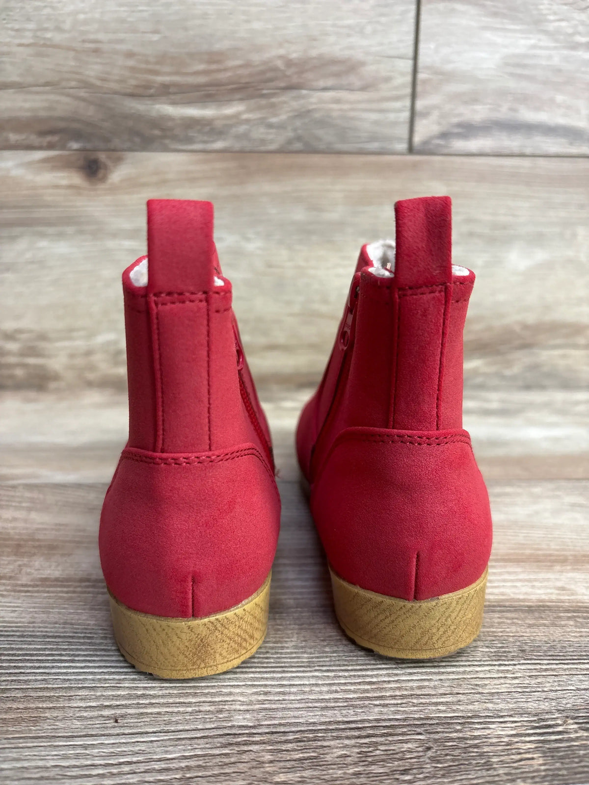 Front view of red Cat & Jack Etta toddler ankle boots with tan soles and side zippers on a wood floor