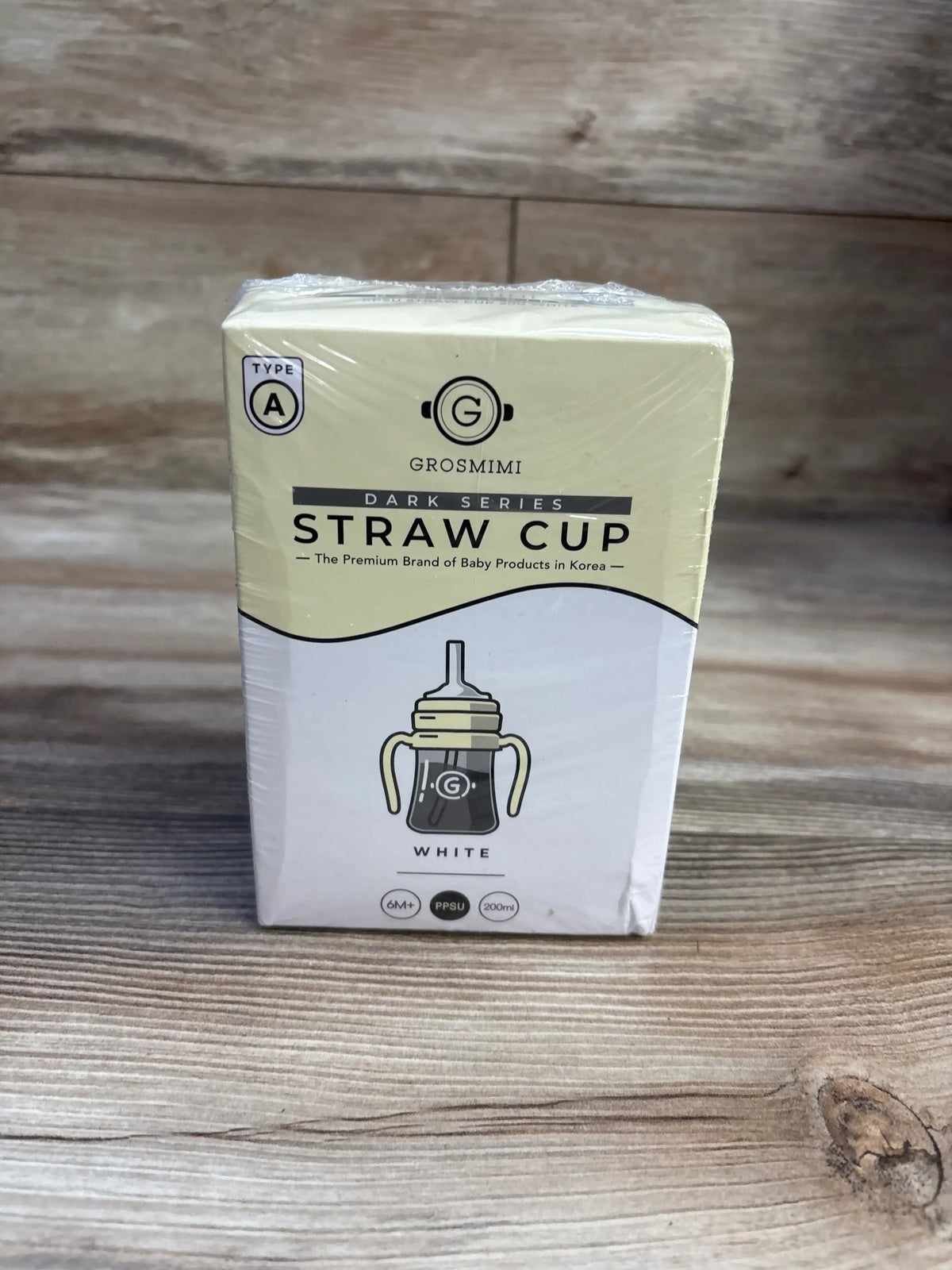 Front view of Grosmimi PPSU straw cup box showing white cup graphic and 6oz 200ml 6 months labeling on wooden background