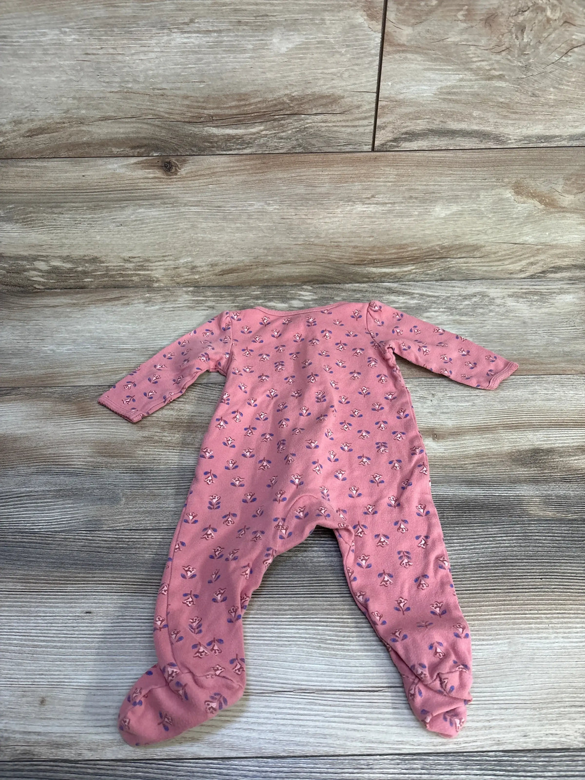 Front view of Carter’s Little Sister pink footed sleeper sz 6m showcasing ditsy floral print with long sleeves on wood plank background