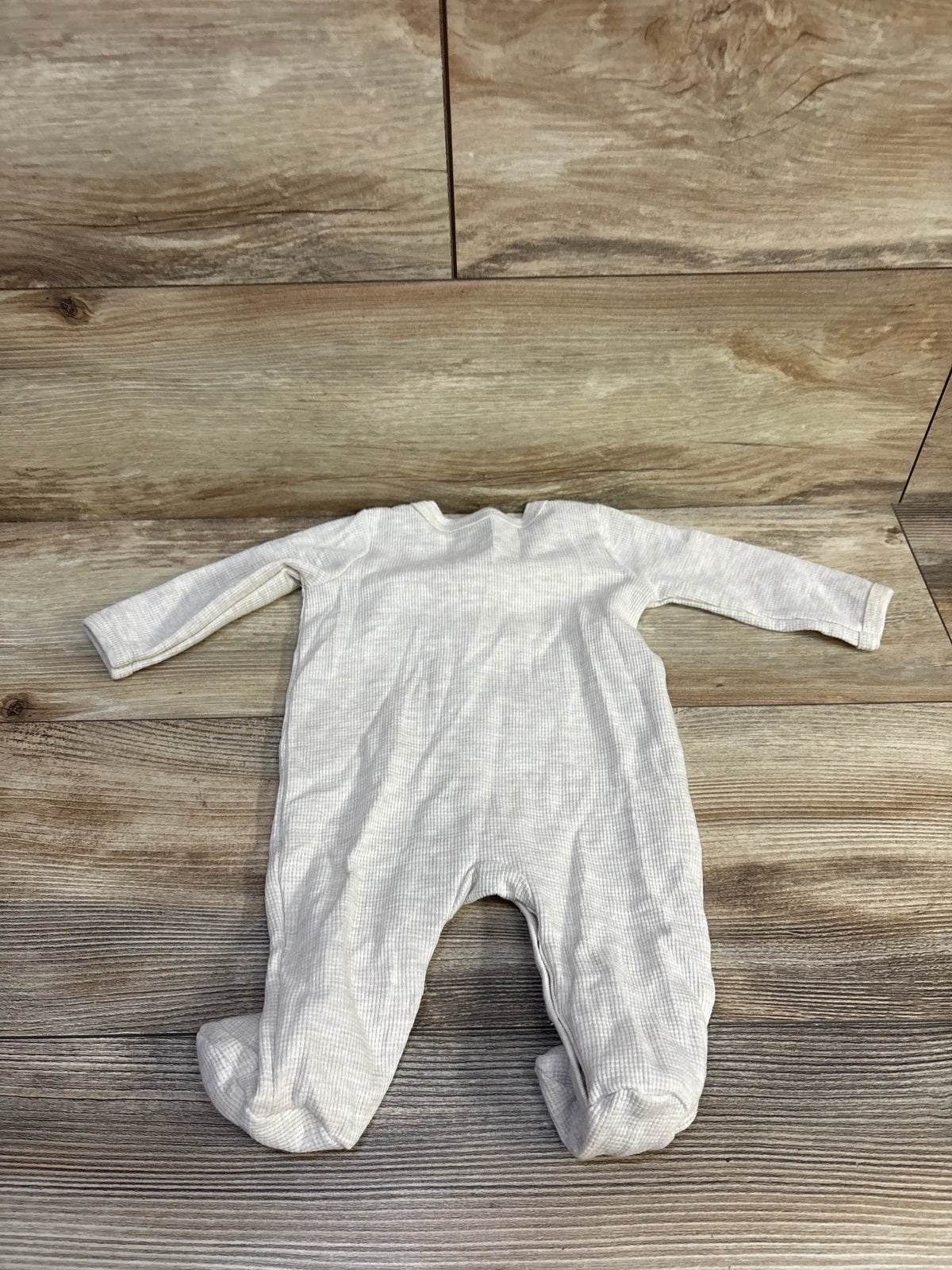 Flat lay of Koala Baby waffle-knit snap sleeper showing waffle texture, long sleeves, and footed legs on wood background