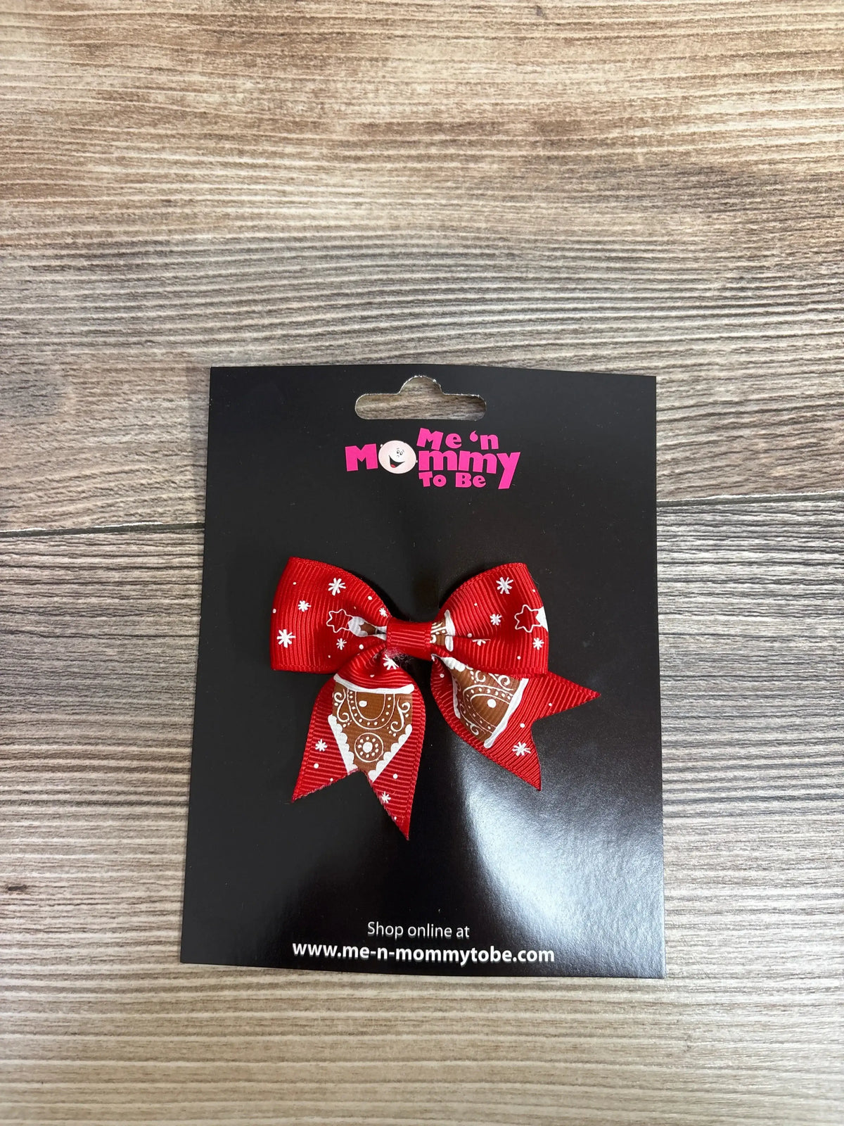 Red holiday bow with gingerbread design for kids, festive accessory on black card
