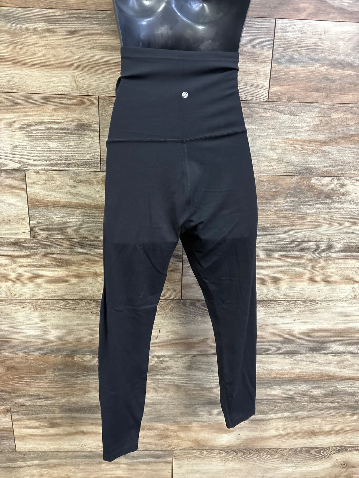 Front flat view of CRZ Yoga cropped maternity leggings showing high fold-over waistband and cropped legs on wood floor background