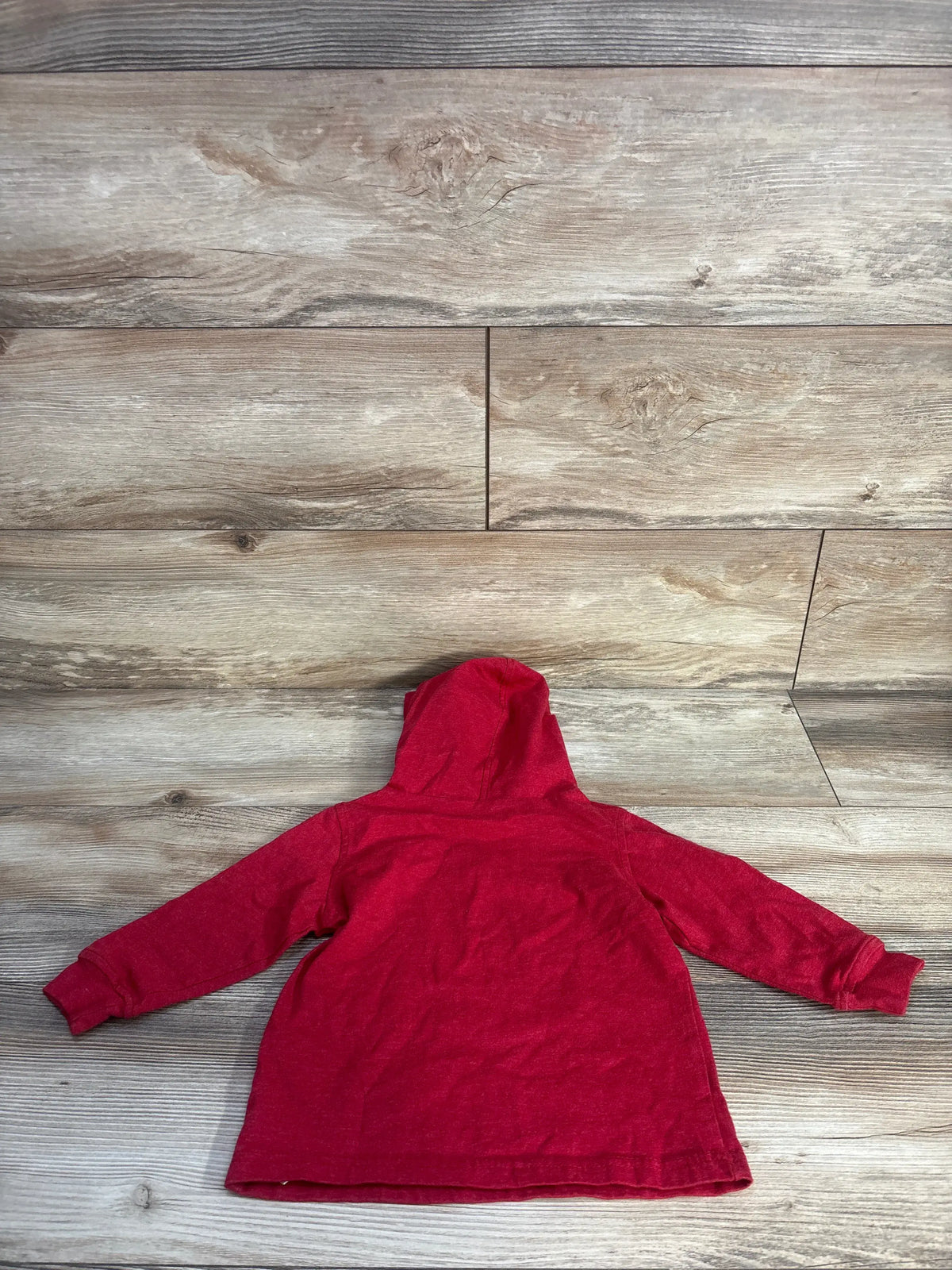 Back view of red Calvin Klein toddler hooded shirt showcasing attached hood and long sleeves on wood plank background