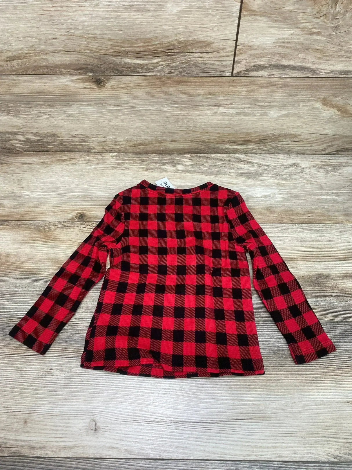 Flat lay of Old Navy toddler long-sleeve red and black buffalo check shirt, size 2T, on light wood background
