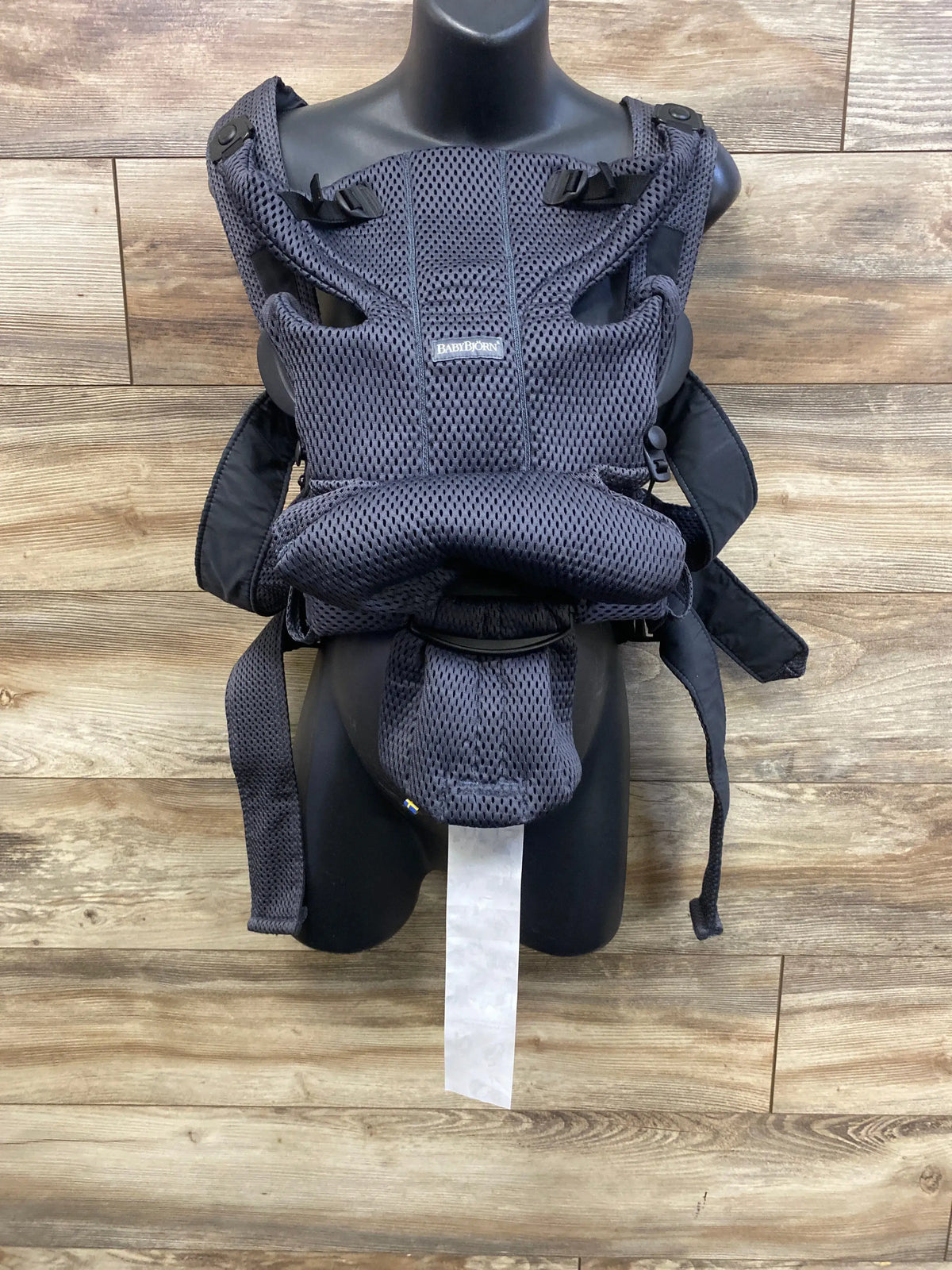 Front view of BabyBjörn Baby Carrier Free in anthracite showcasing 3D mesh and padded support on a wood floor