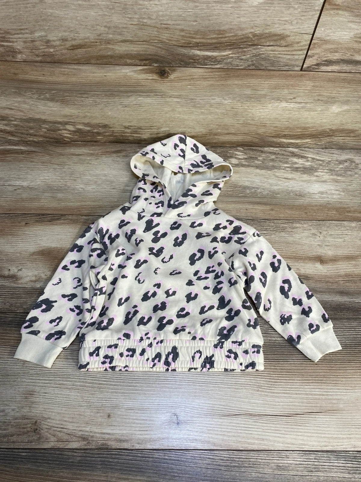 Kids' cream hoodie with purple and black animal print, long sleeves, on wood background