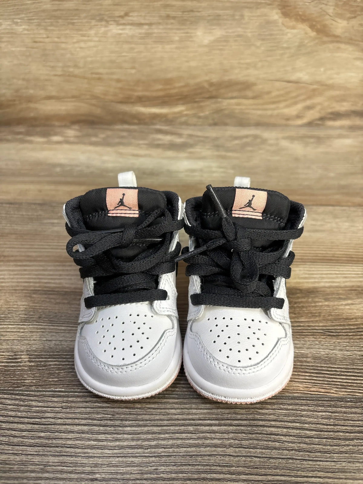 Front view of white and black Air Jordan 1 Mid TD White Arctic Orange toddler sneakers.