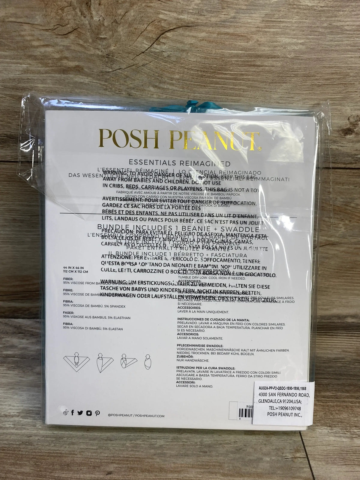 Back view of Posh P swaddle and beanie set in Buddy showing 44 by 44 inch dimensions and care instructions on a wooden surface