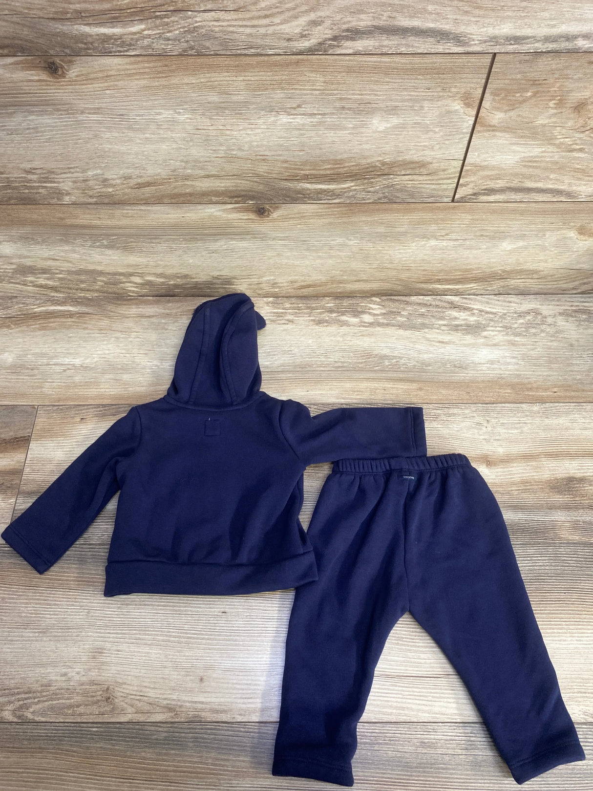 Navy blue toddler hoodie and matching pants set on wood floor