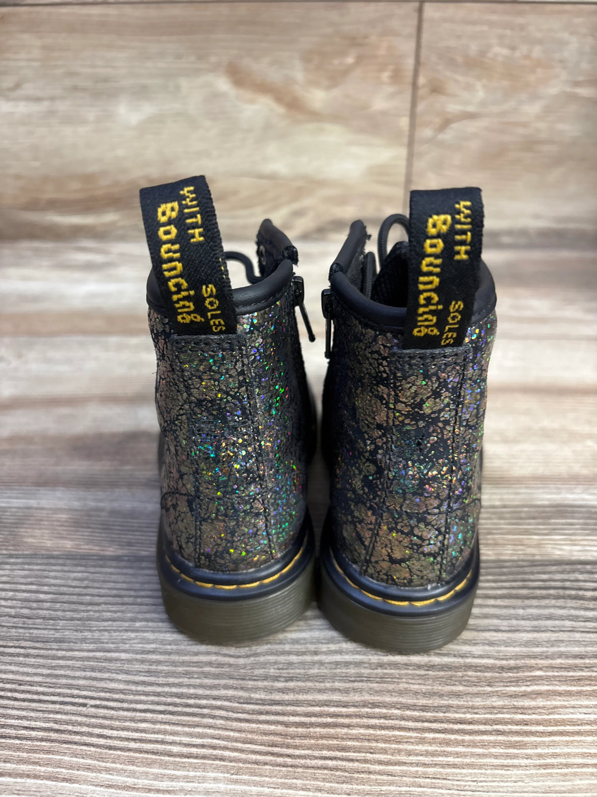 Back of Dr Martens 1460 boots size 7C showing crinkle metallic glitter and yellow With Bouncing Soles heel loop on wood floor