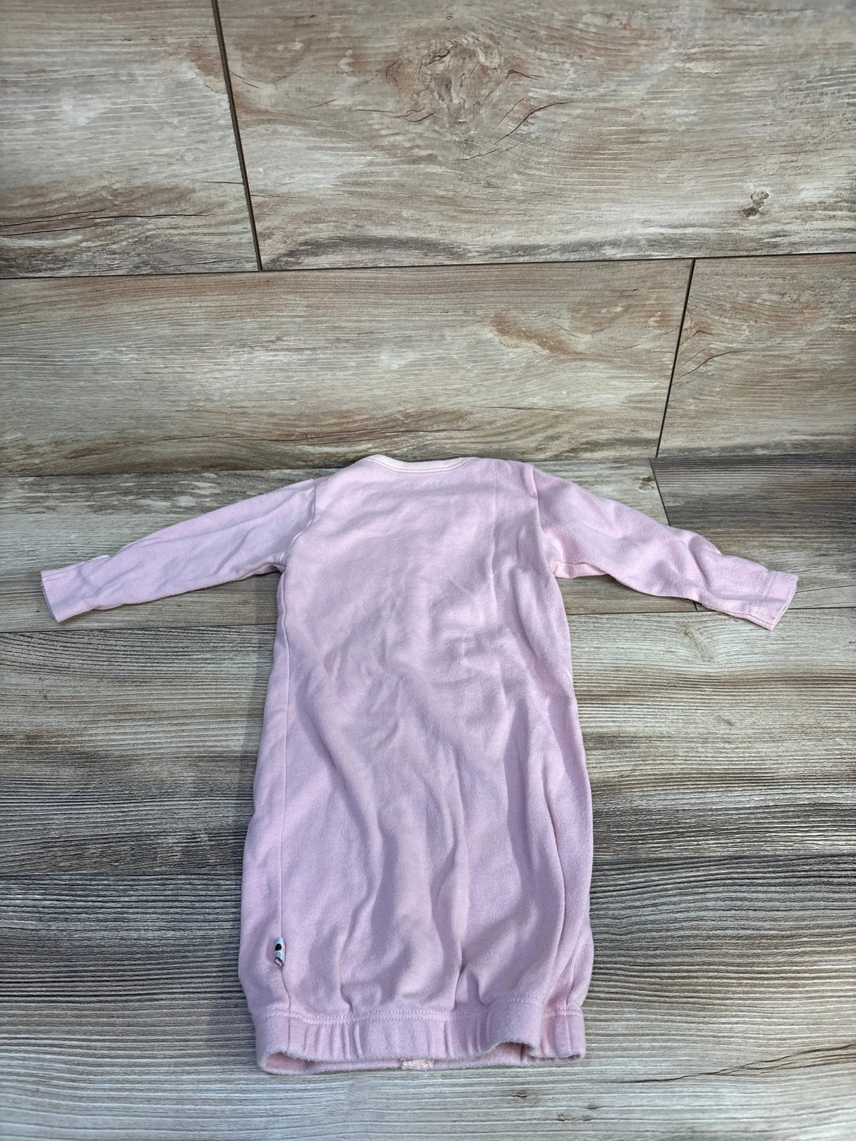 Back view of Babysoy pink snap sleep gown, size 3 to 6 months, with long sleeves and gathered hem on wood-look flooring