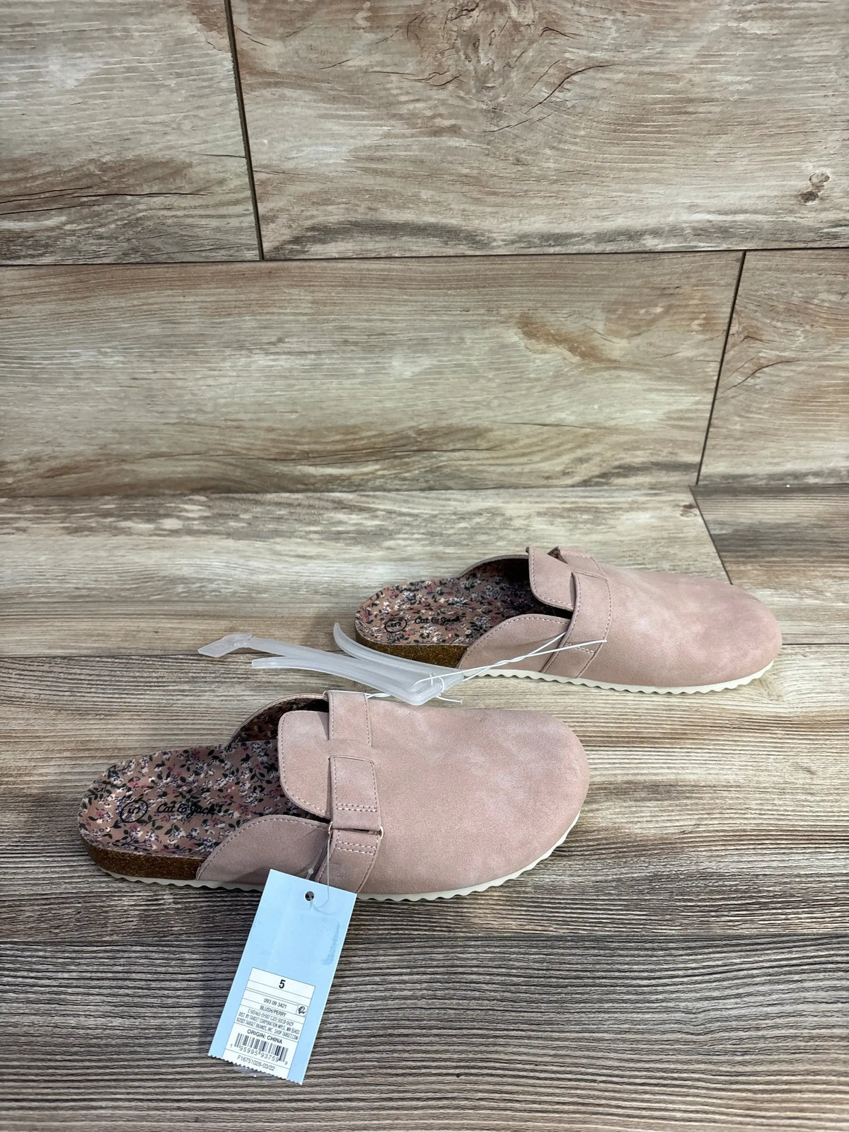 Pair of size 5 pink Cat & Jack slip-on mules with floral inner sole on wooden floor