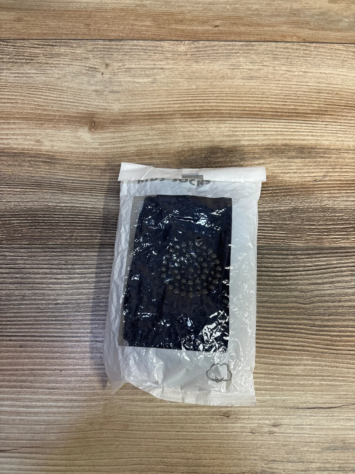 Front view of NEW navy baby knee pads in clear packaging showcasing raised cushioning on a wood grain background