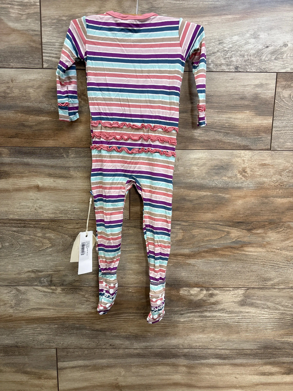 Kickee Pants Love Stripe Ruffle Zip Footie in pink, size 18-24m, on a wooden background