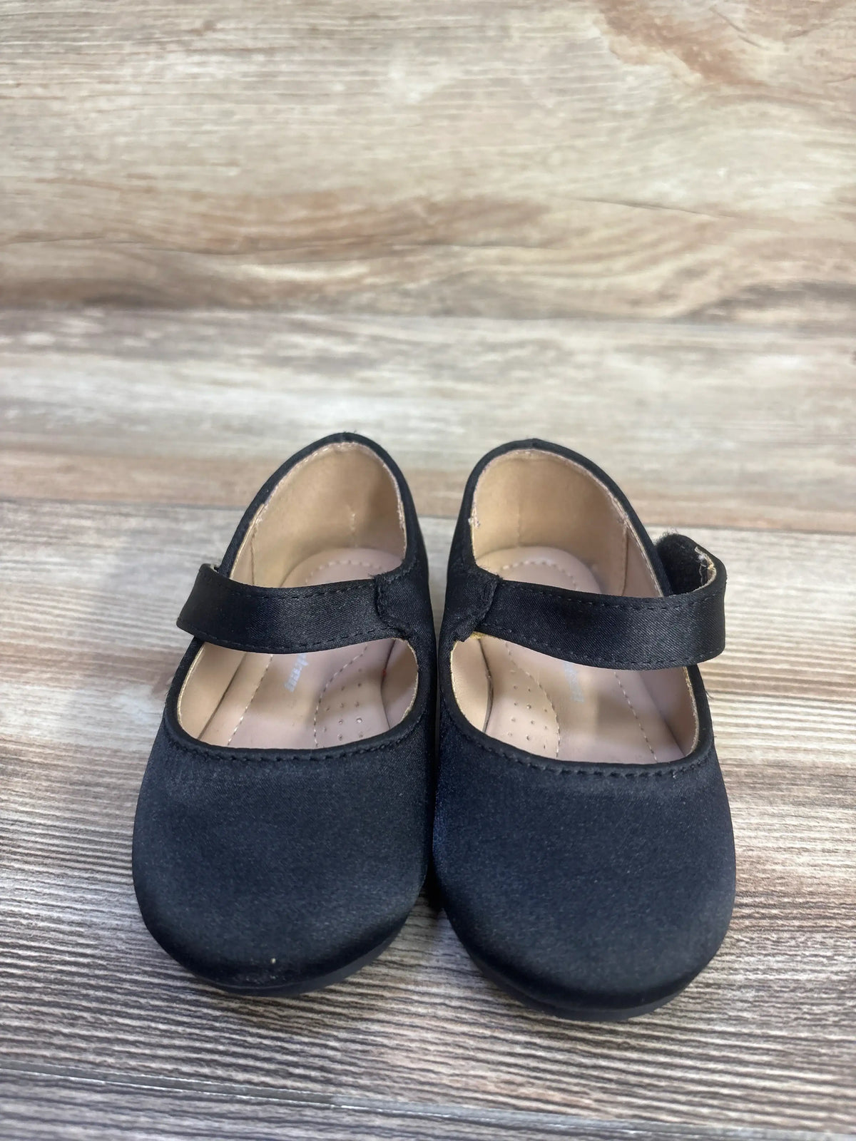 Front view of black FunkyMonkey Mary Jane ballet flats, size 6C, showcasing Velcro straps on a wood-look surface