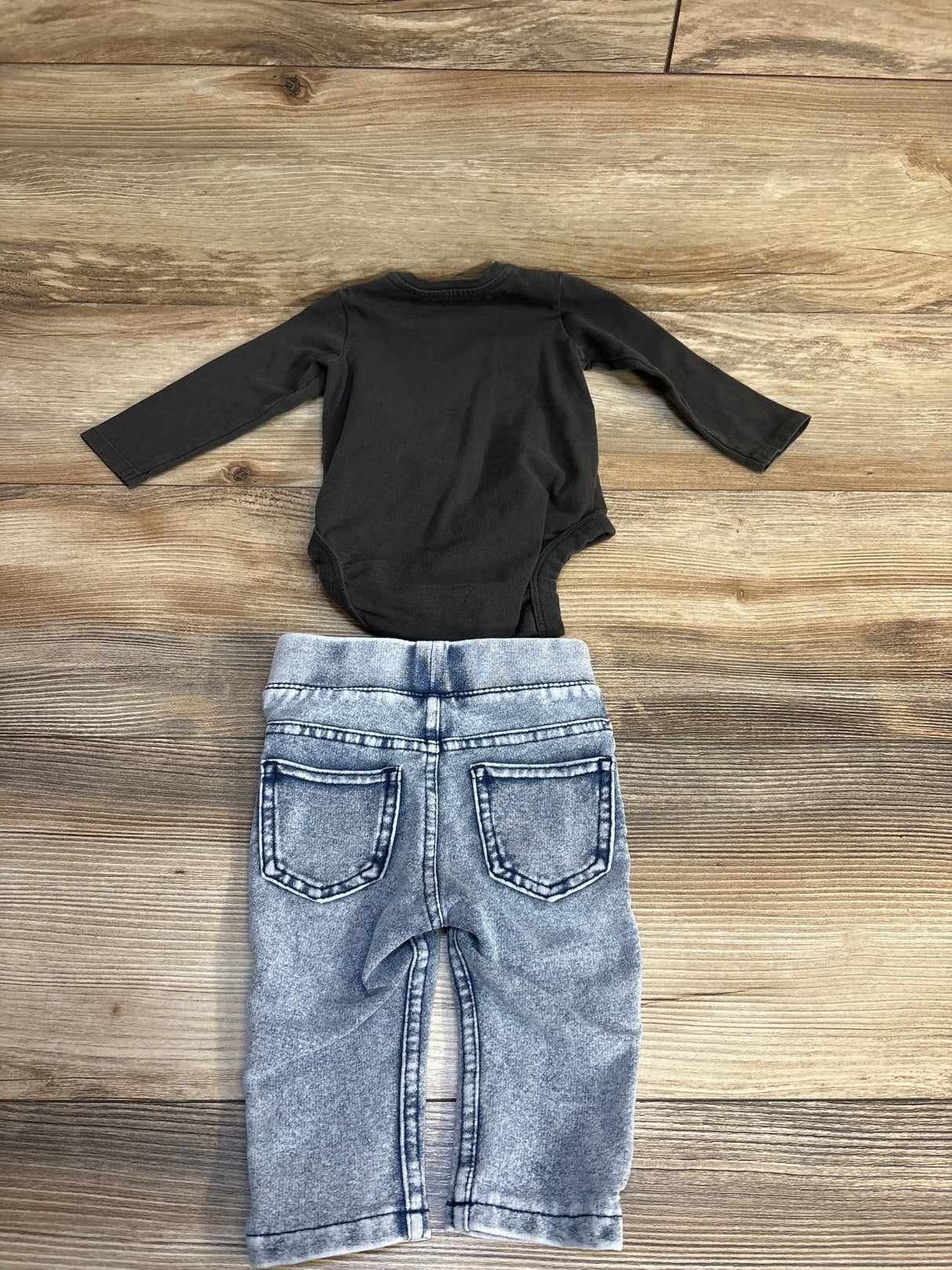 Back view of H&M x Guns N Roses 2pc Bodysuit and Acid Wash Leggings Set Grey sz 3m showcasing charcoal long-sleeve bodysuit and acid-wash denim leggings on wood plank floor
