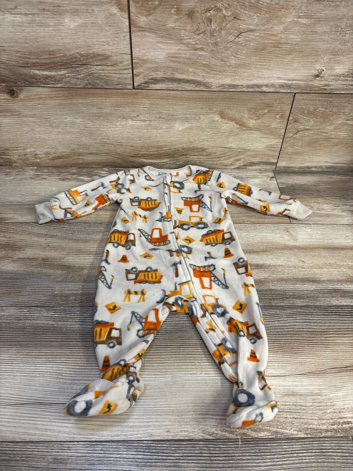 Front view of Kids Headquarters tan construction sleeper showcasing printed vehicles, front zipper, and footed legs on wood-look floor