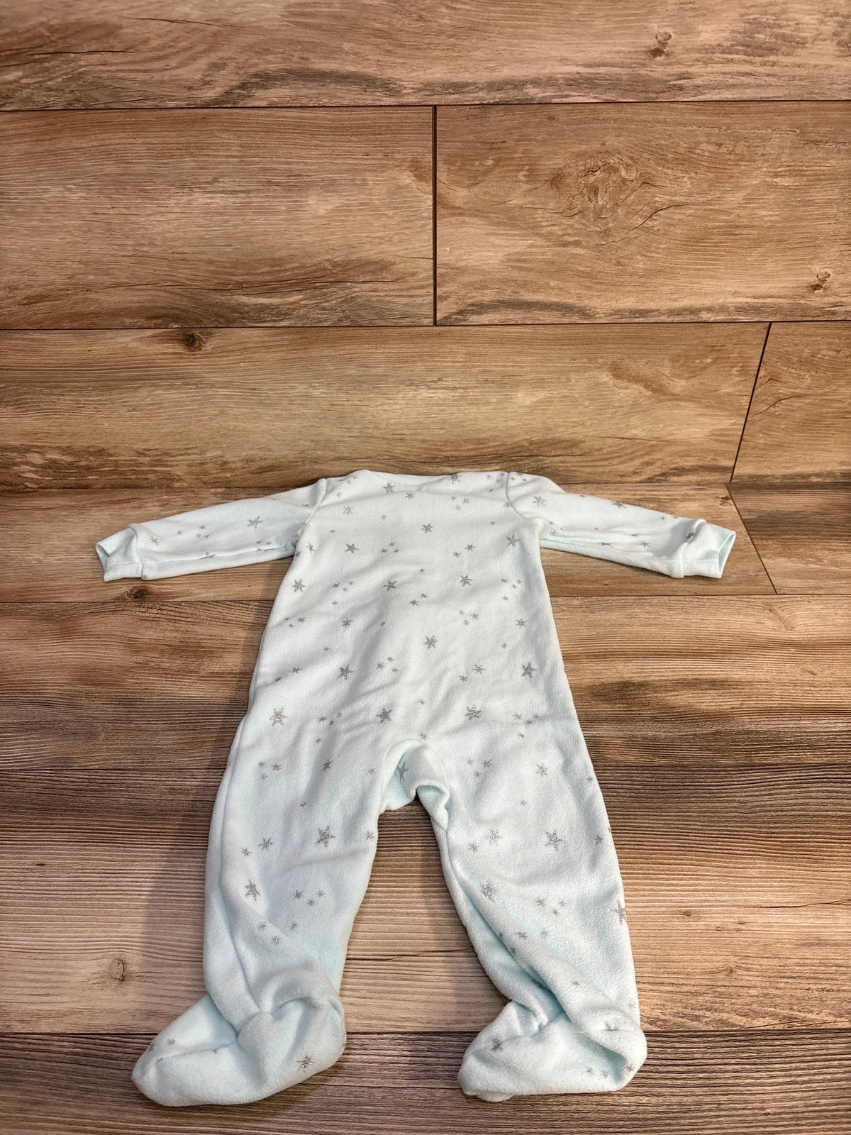 Front view of Carter’s blue 9-month blanket sleeper showcasing star pattern and footed legs on wood background