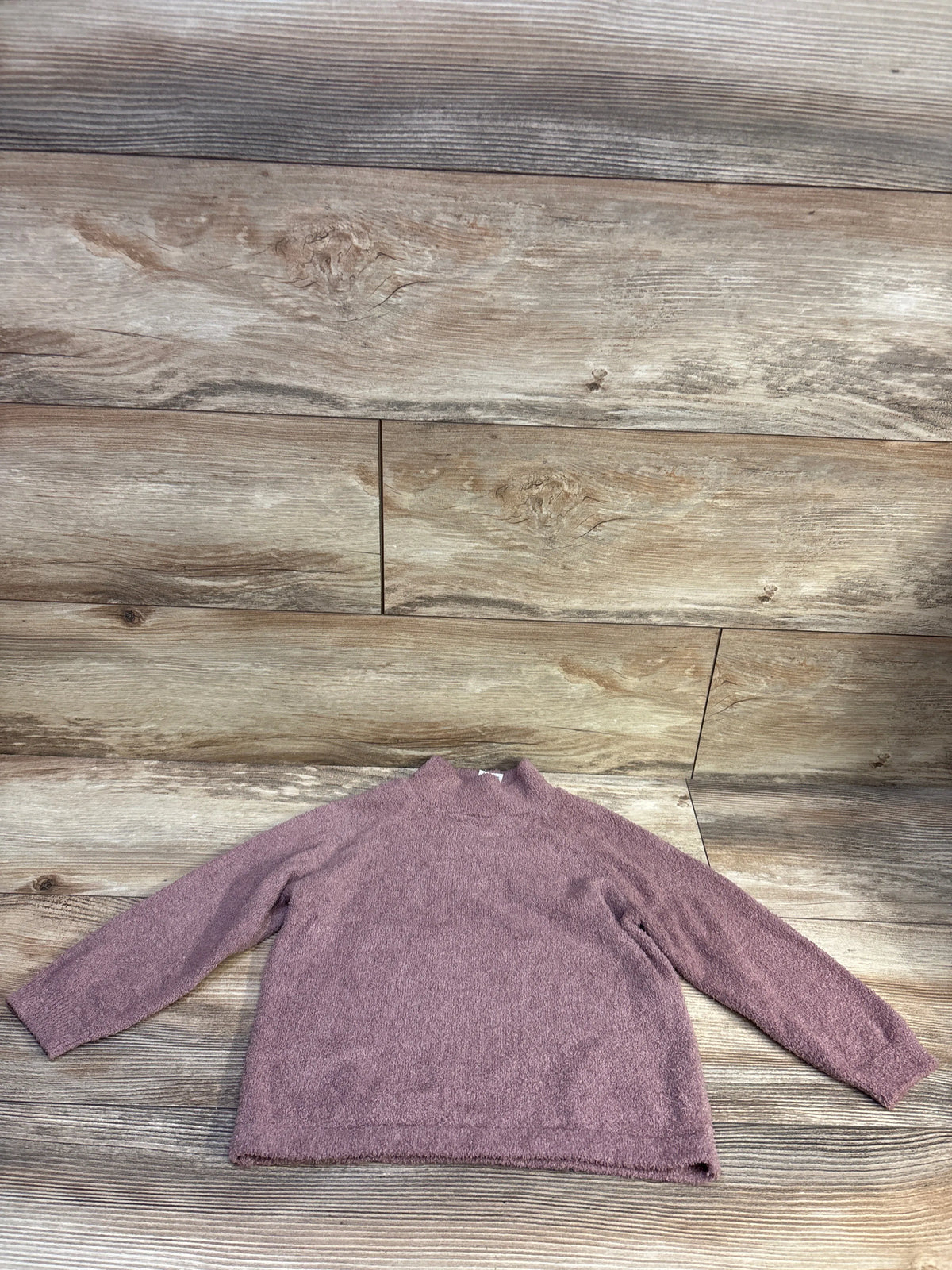 Flat lay of mauve Modern Moments fuzzy knit sweater, size 3T, with long sleeves on a wood-look background
