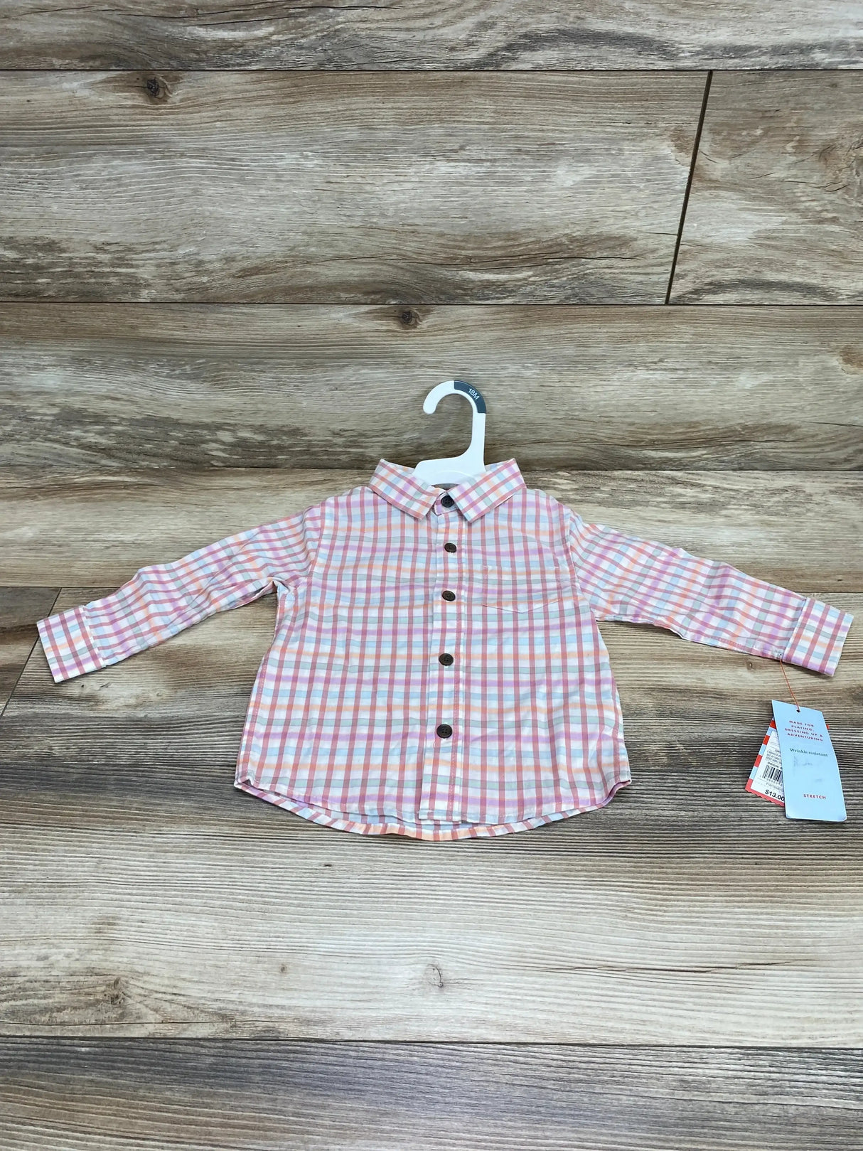 Front view of toddler Cat & Jack long-sleeve pink and white plaid button-up shirt showing brown buttons on a wood floor background