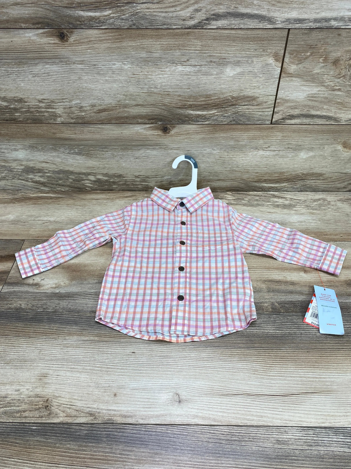 Front view of toddler Cat & Jack long-sleeve pink and white plaid button-up shirt showing brown buttons on a wood floor background