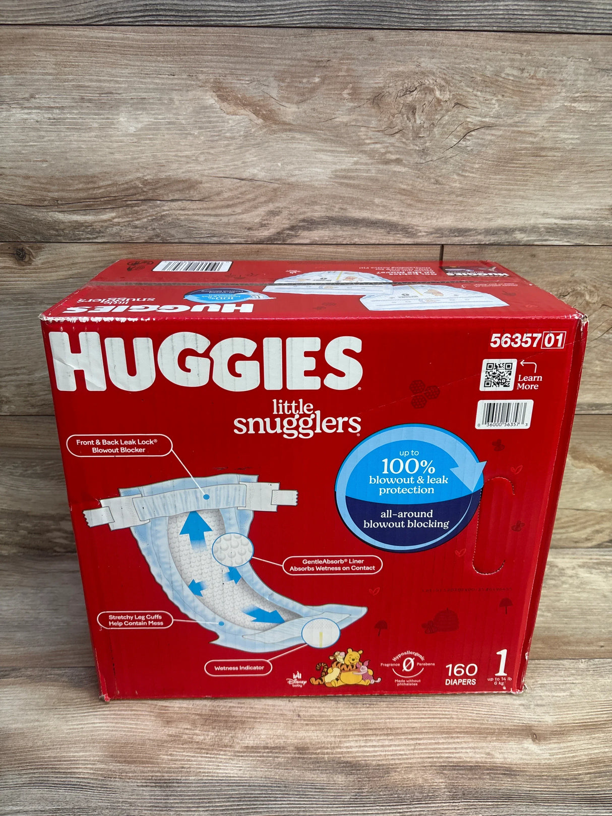 Front view of Huggies Little Snugglers size 1 box showing HUGGIES logo, 160-count and 100% blowout protection badge on wood
