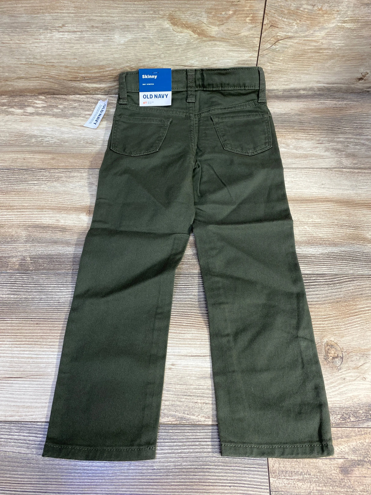 Olive green kids skinny pants Old Navy, back view, on wood background, gently used children’s clothing
