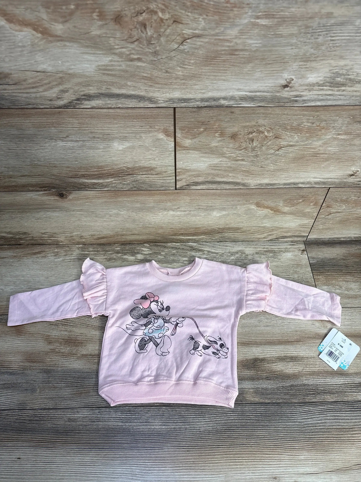 Pink toddler sweatshirt with ruffled sleeves featuring Minnie Mouse walking a dog graphic