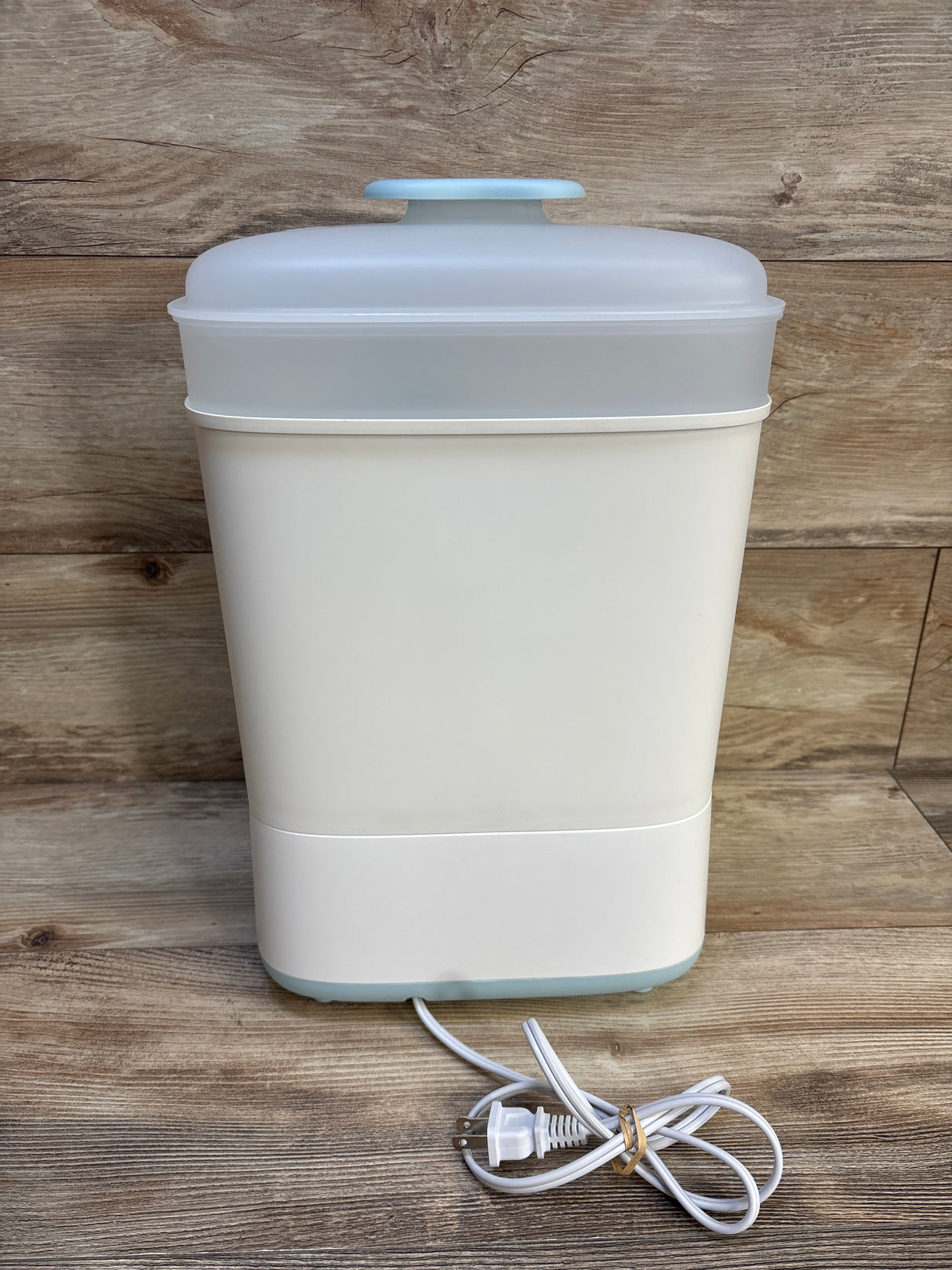 Front view of Papablic Baby Bottle Sterilizer and Dryer showing translucent lid and included power cord on wood background