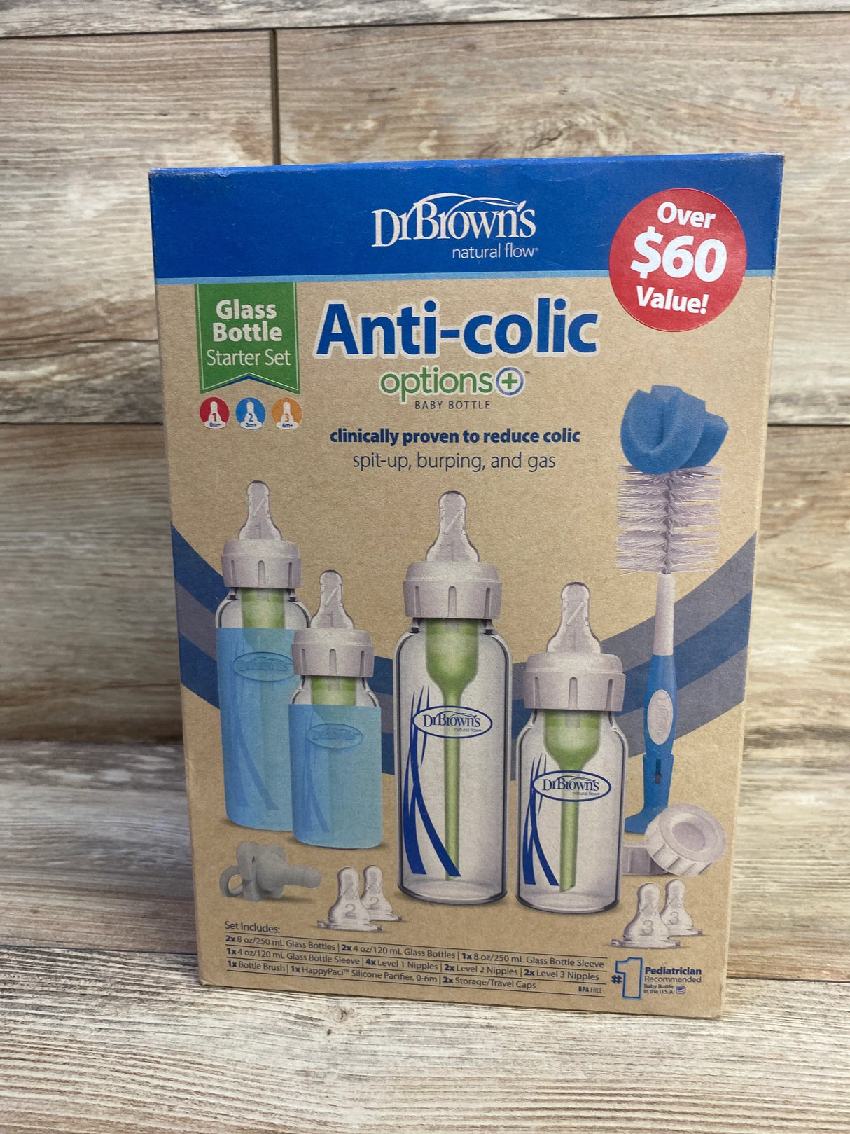 Front view of NEW Dr Browns Anti-Colic Options Narrow Glass Baby Bottle Starter Set in original retail box on wood plank floor