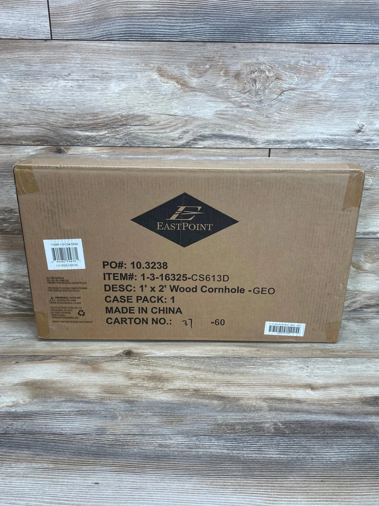 Front of boxed 1 x 2 foot wood cornhole set showing EastPoint logo and printed 1 x 2 Wood Cornhole GEO on wood plank background