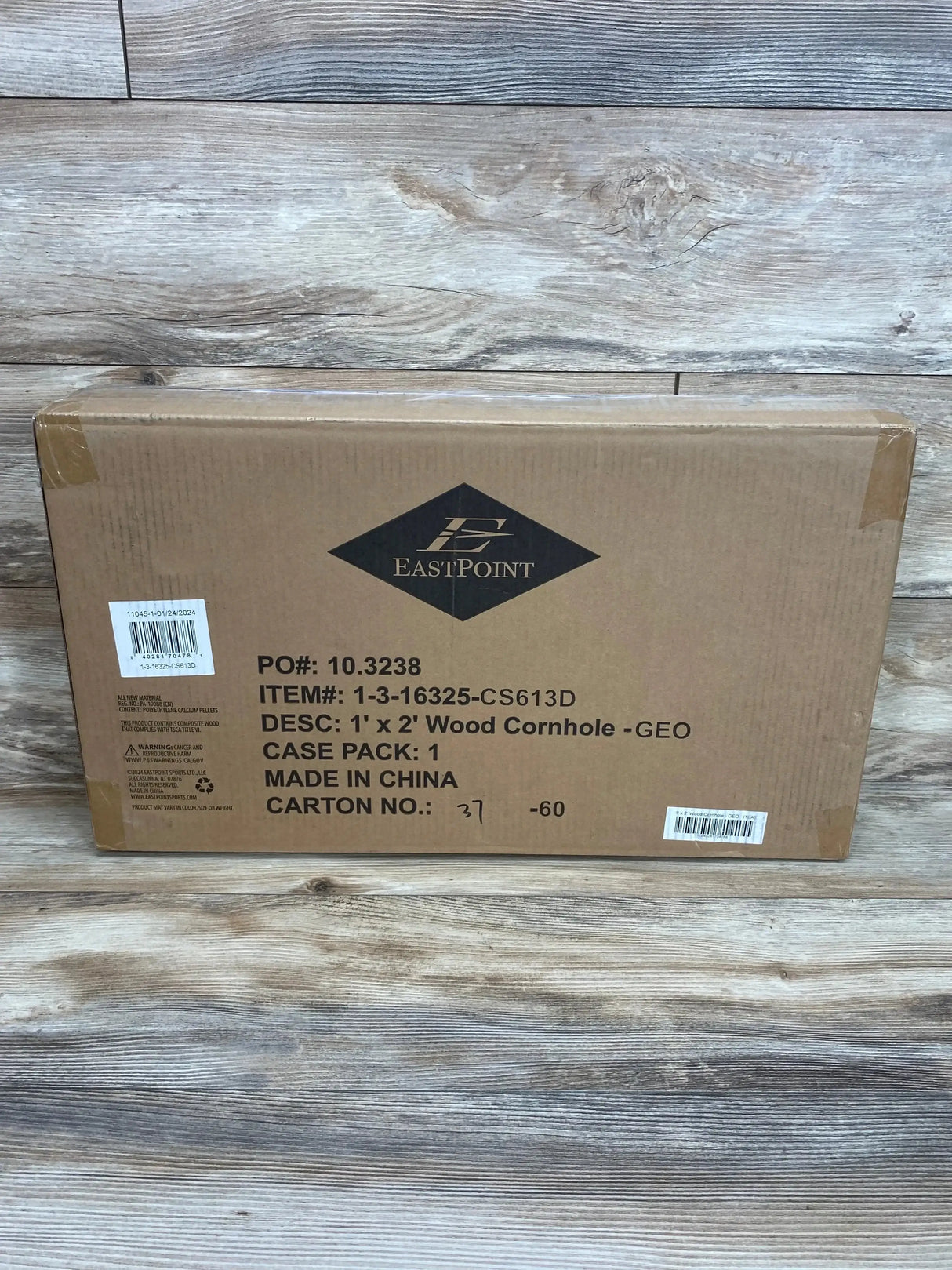 Front of boxed 1 x 2 foot wood cornhole set showing EastPoint logo and printed 1 x 2 Wood Cornhole GEO on wood plank background