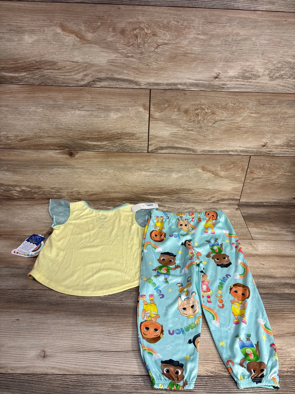 Toddler yellow top with blue ruffled sleeves and colorful pajama pants with animated character prints