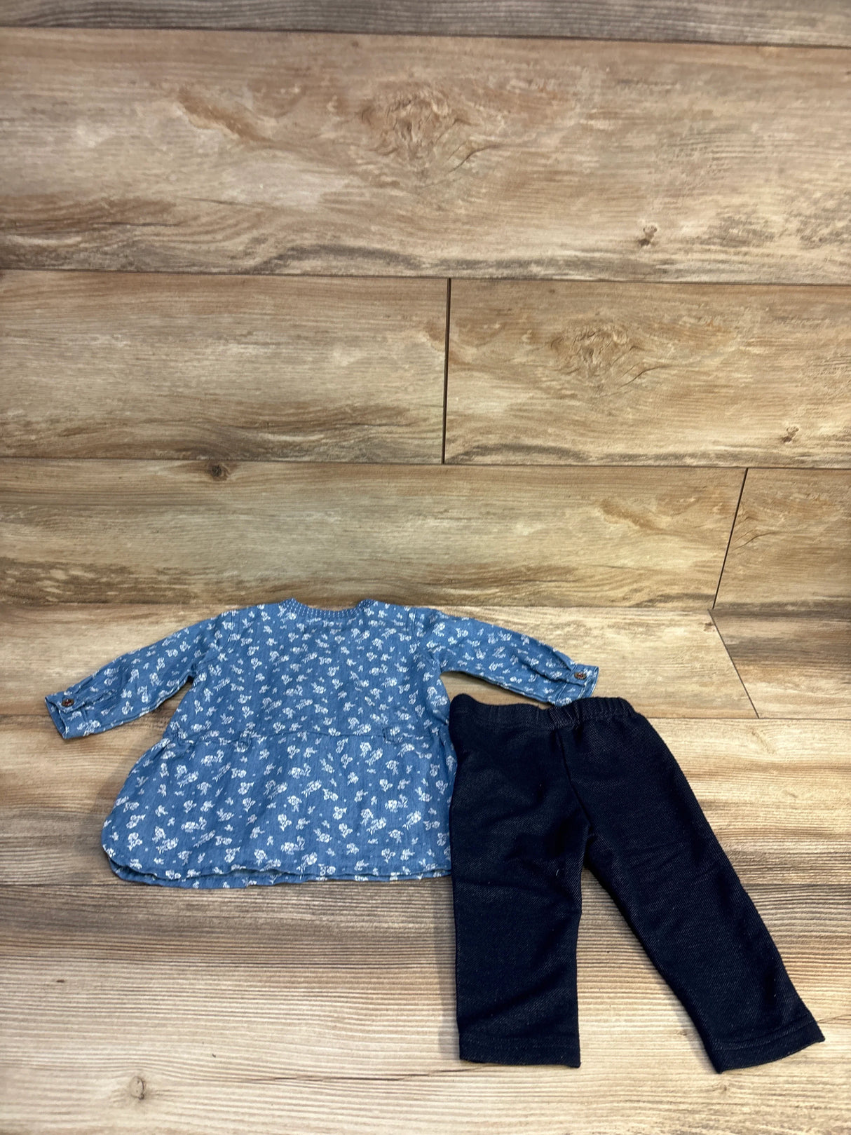 Flat lay of blue chambray long-sleeve dress with white floral print paired with dark navy stretch jeggings on wood background