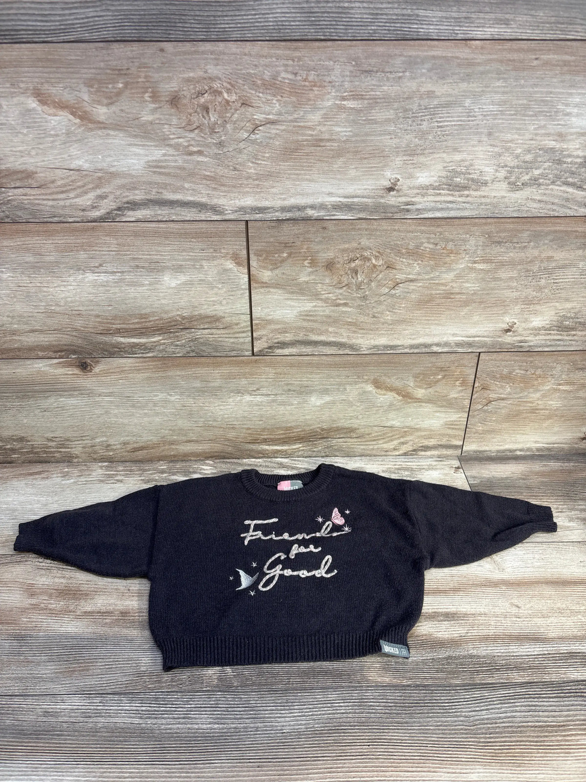 Front view of grey Modern Moments x Wicked sweater with Friends are Golden design and long sleeves on wood flooring