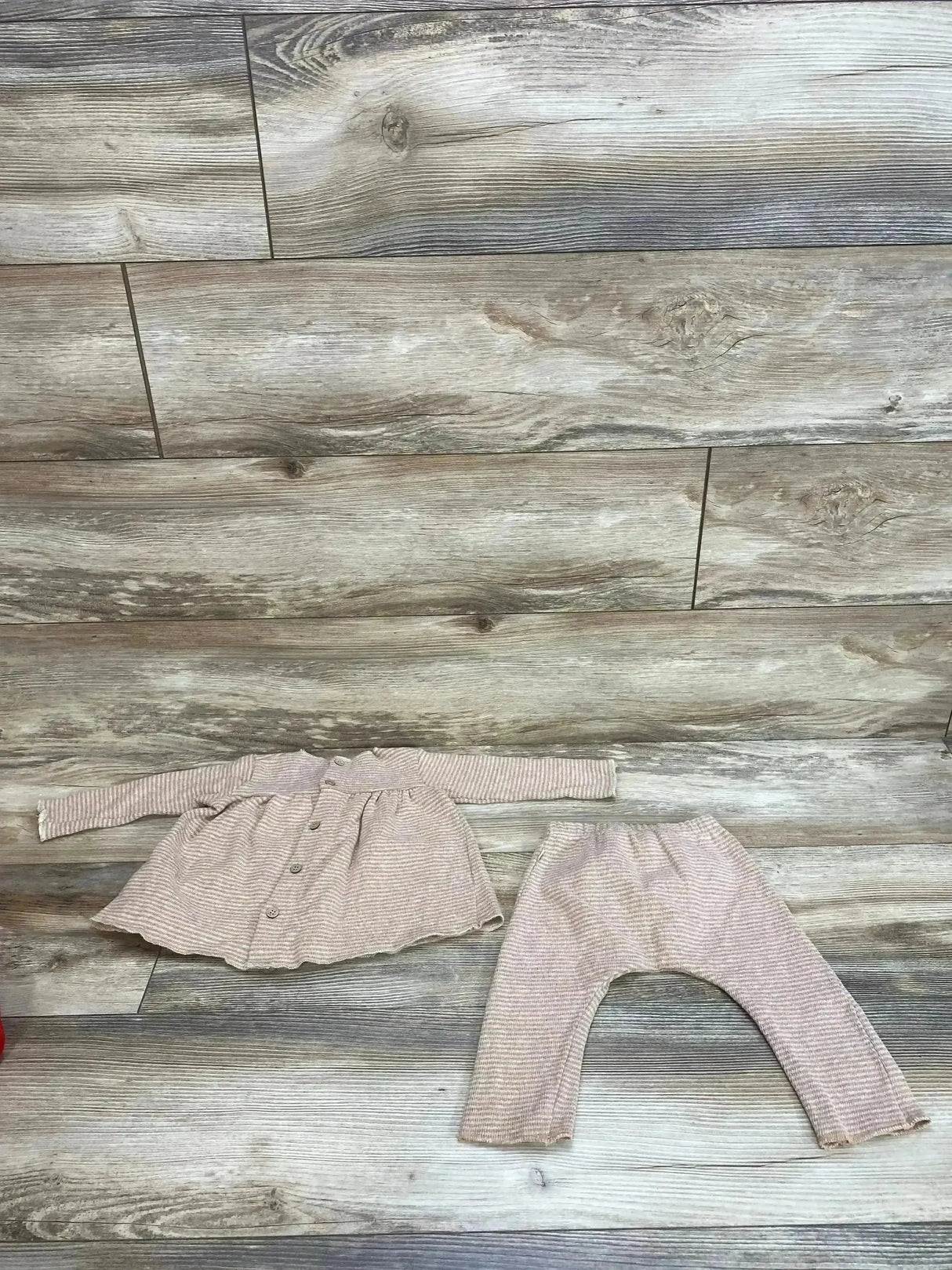 Flat lay of 1 + In The Family striped blush blouse and pants set size 6m showcasing soft pink ribbed button-front top and matching pants on wood plank floor