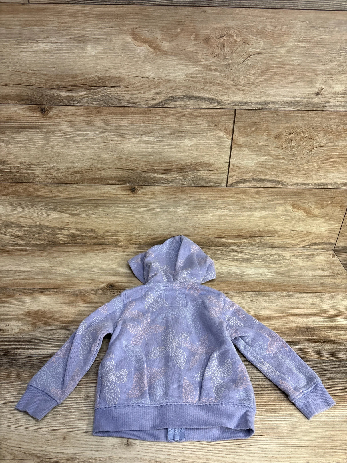 Lavender kids hoodie with floral white and pink patterns on wooden floor background