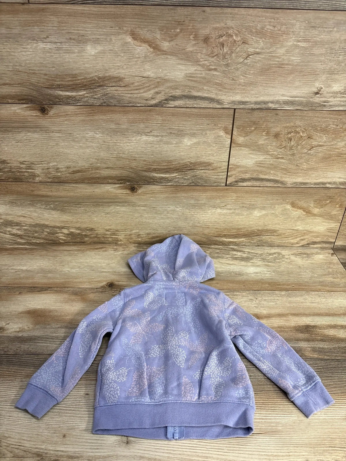 Lavender kids hoodie with floral white and pink patterns on wooden floor background