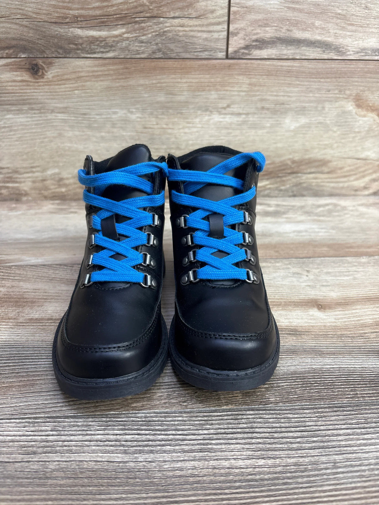 Black kids boots with blue laces on wood floor, children's footwear resale