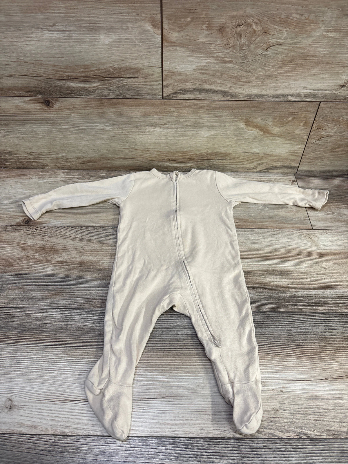 Front view of beige Old Navy sleeper, size 6-9m, with long sleeves, footed legs, and front zipper on a wood-grain background