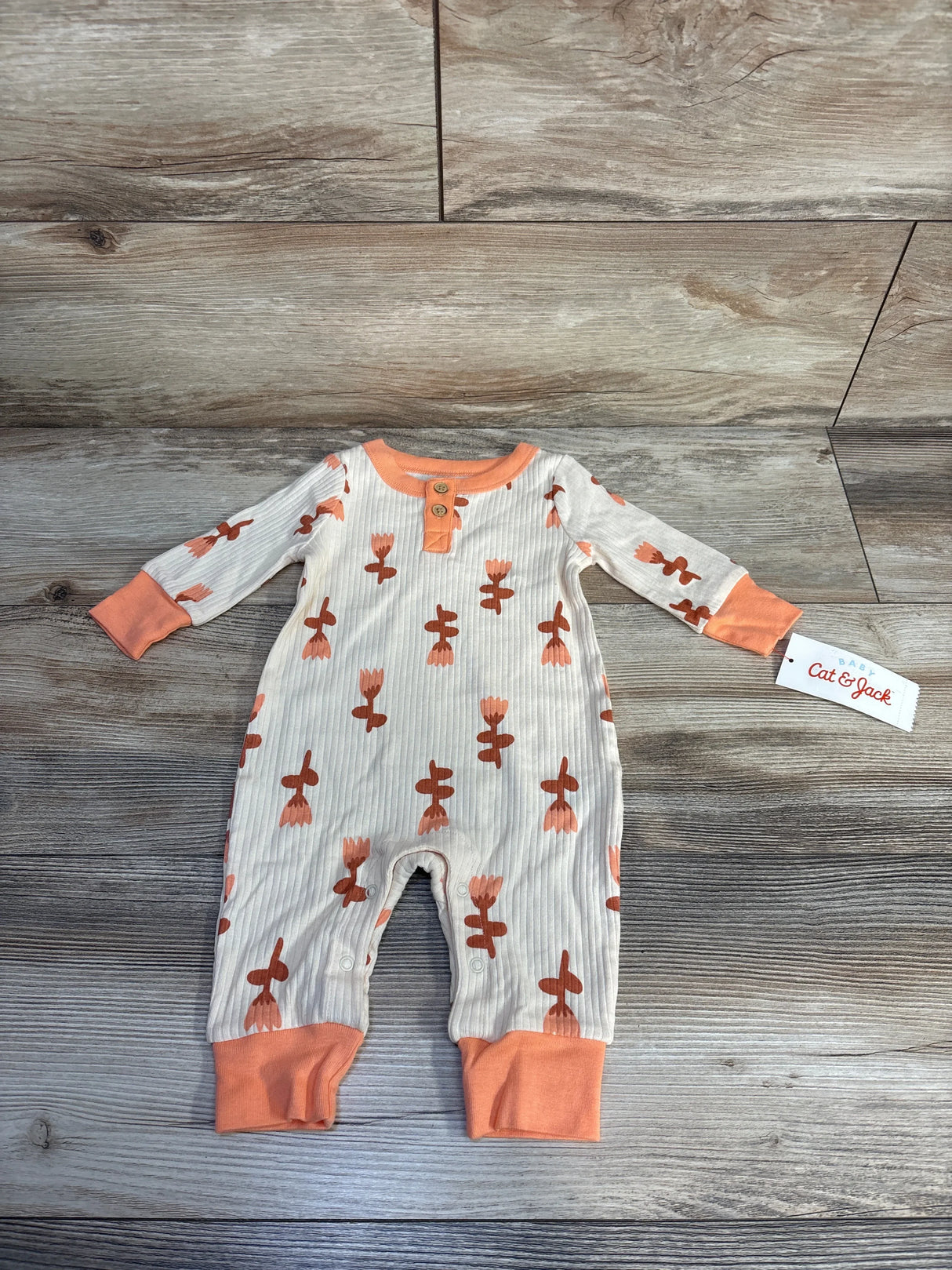 Baby Cat & Jack long-sleeve ribbed romper with orange floral print and cuffs on wooden floor