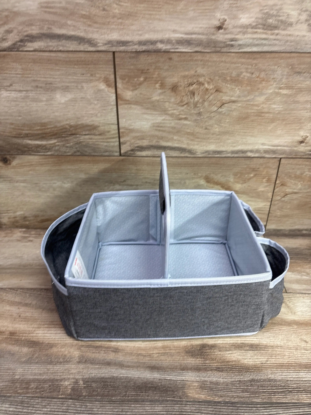 Front view of Munchkin Portable Diaper Caddy Organizer showing grey fabric, divided interior, and carry handles