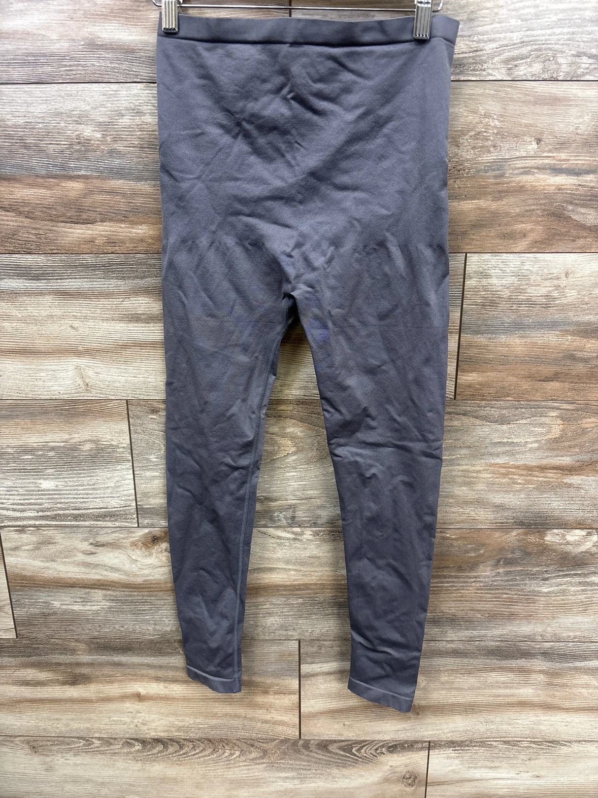 Dark gray high-waisted maternity leggings on wooden background, gently used kids clothing