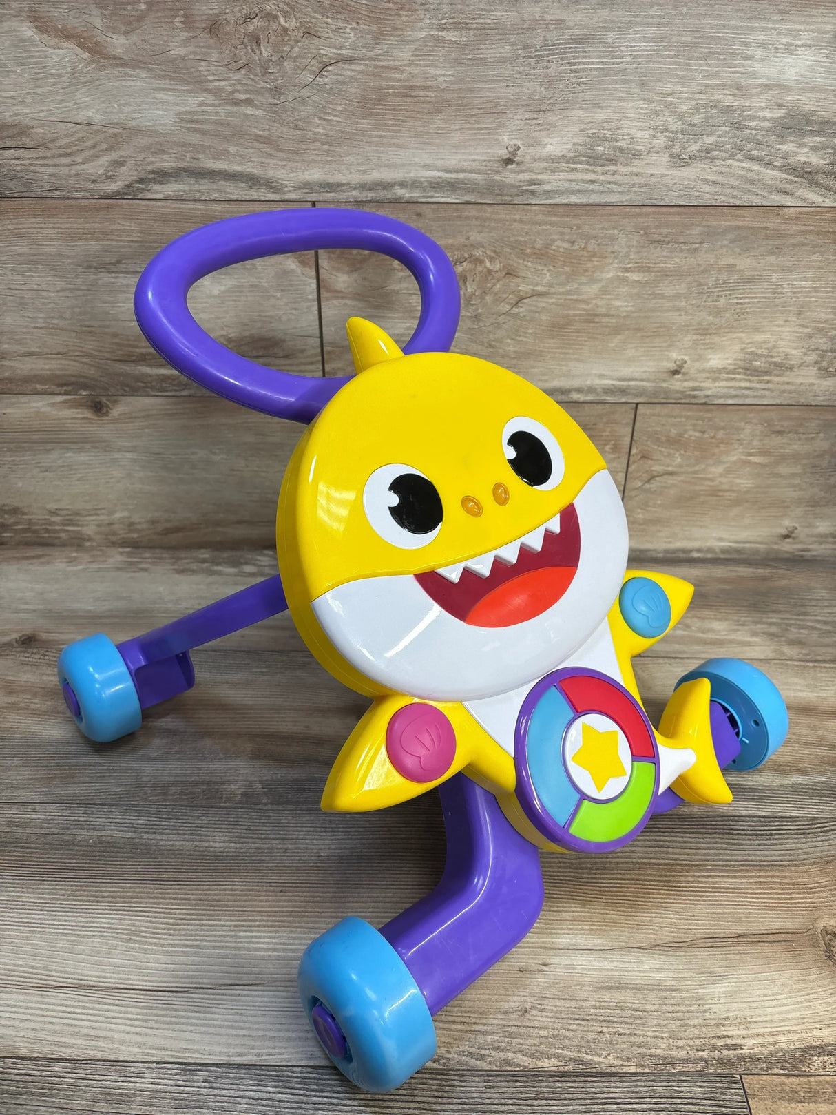 Yellow Baby Shark push toy with purple handle and blue wheels for toddler learning to walk