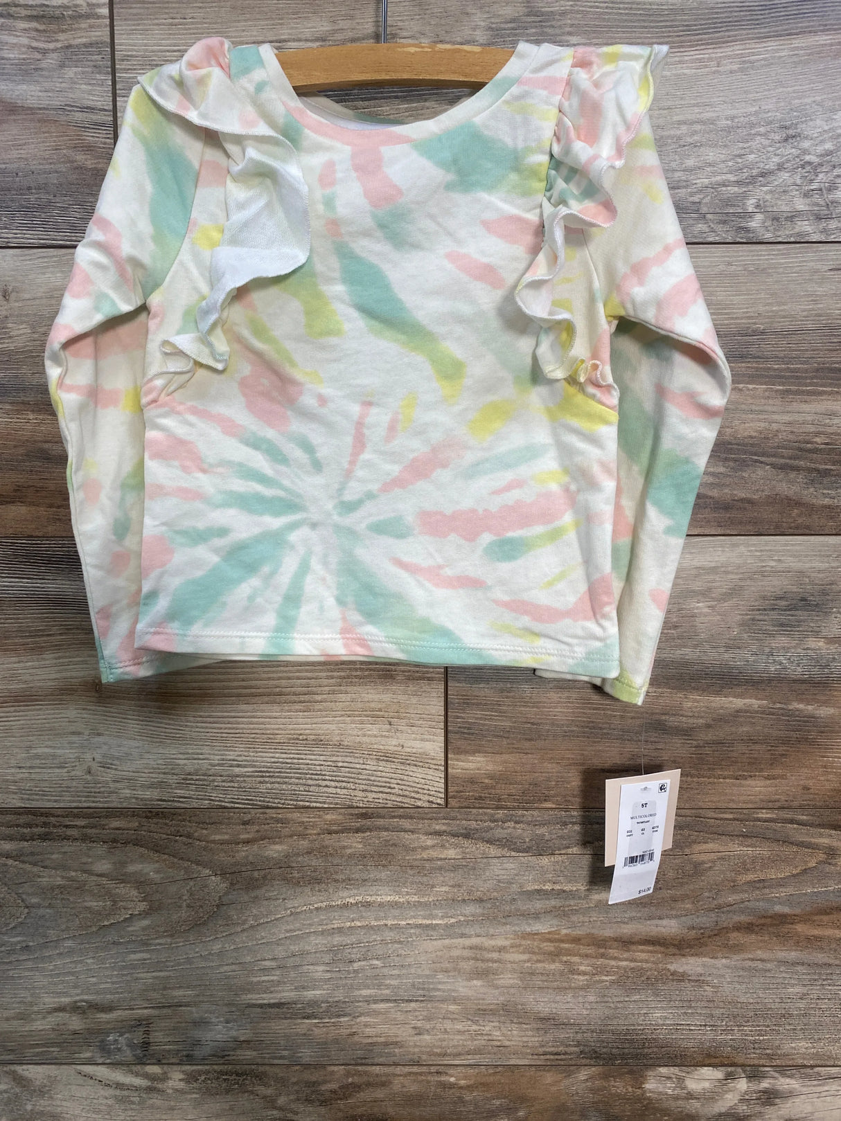 Toddler tie-dye long sleeve shirt with ruffle detail on shoulders, hanging on wooden hanger